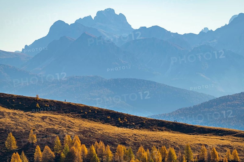Hikers on autumnal ridge with Peitlerkofl in the background