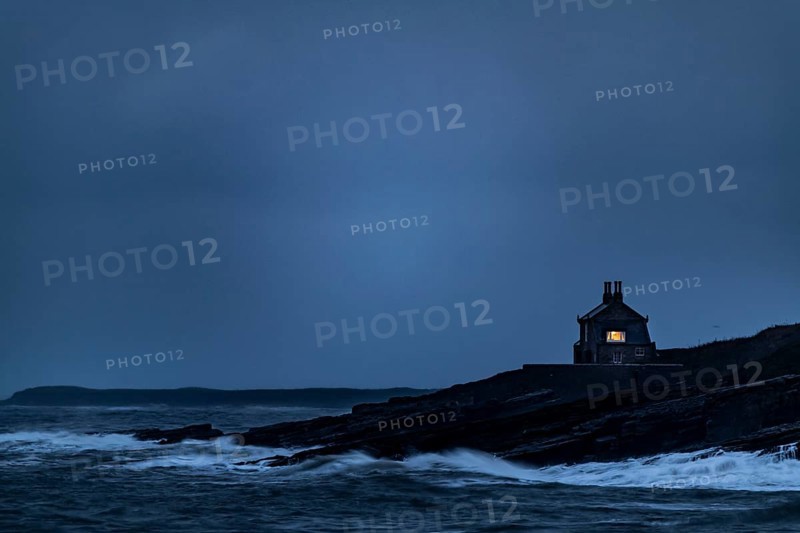 Small house on coast at blue hour