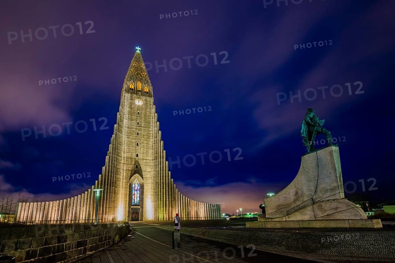 Illuminated church Hallgrimskirkja with monument of Leif Eriksson