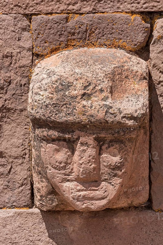 Stone head in wall of Kalasasaya Temple (place of standing stones) with monoliths from the pre-Inca period