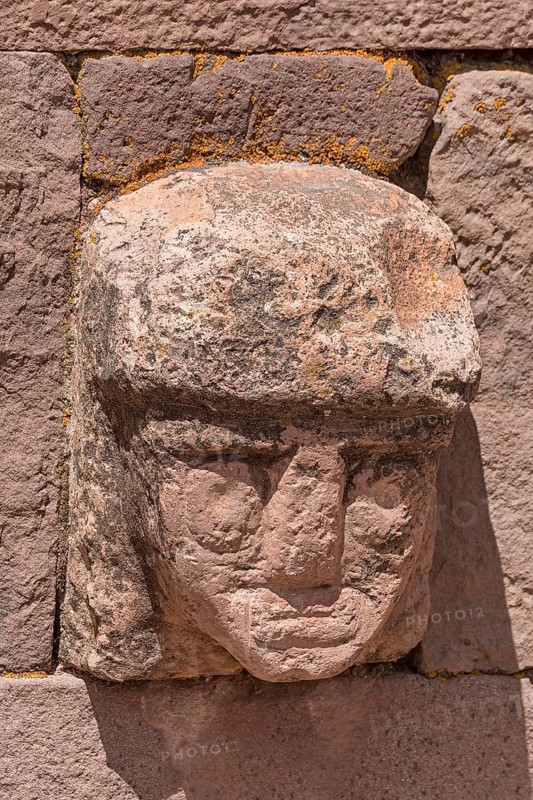 Stone head in wall of Kalasasaya Temple (place of standing stones) with monoliths from the pre-Inca period