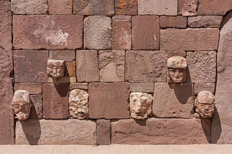 Stone heads in wall of Kalasasaya temple (place of standing stones) with monoliths from pre-Inca period