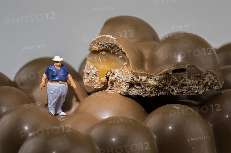Fat man stands on chocolate