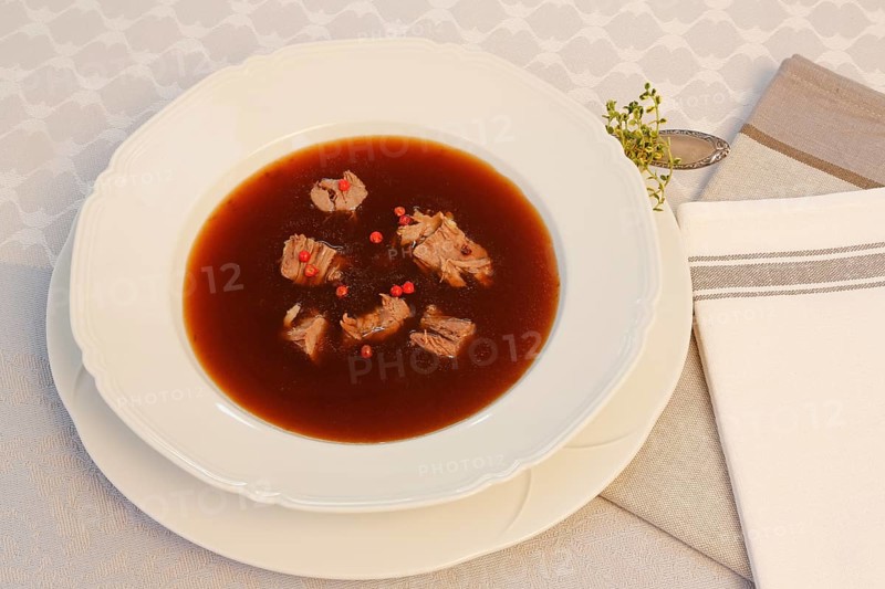 Oxtail soup with red pepper in soup plate