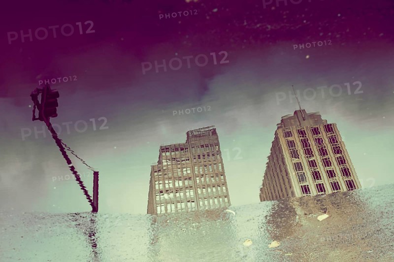 Beisheim Center and traffic light reflected in a puddle