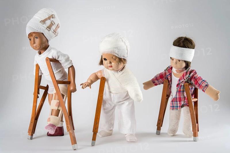 Three dolls walking with crutches