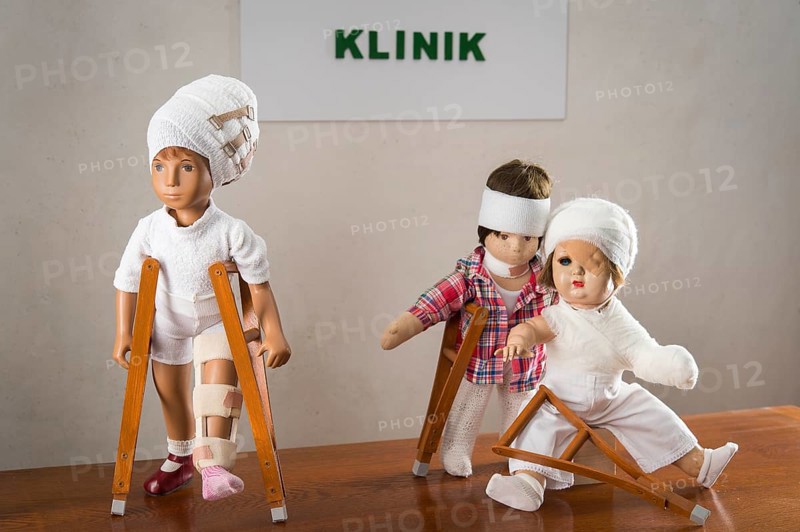 Three dolls walking with crutches