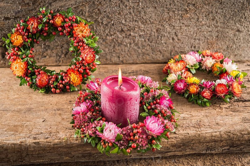 Three small autumn wreaths on wooden plate bonded with rosehip (Rosa canina)