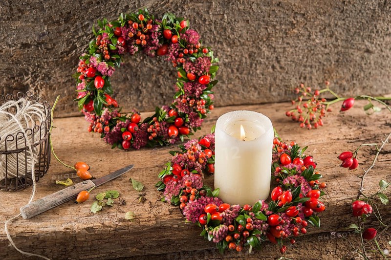 Two small autumn wreaths on wooden plate bonded with rosehip (Rosa canina)