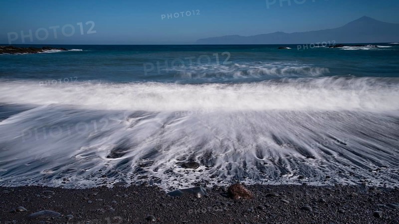 Black pebble beach with wave hem