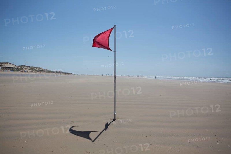 Red flag on the beach warn against dangerous drifts