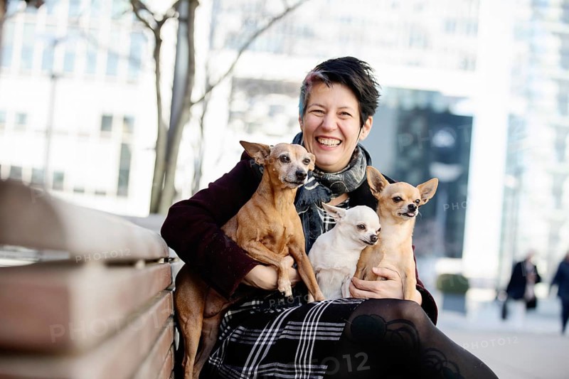 Laughing woman with three dogs on her lap
