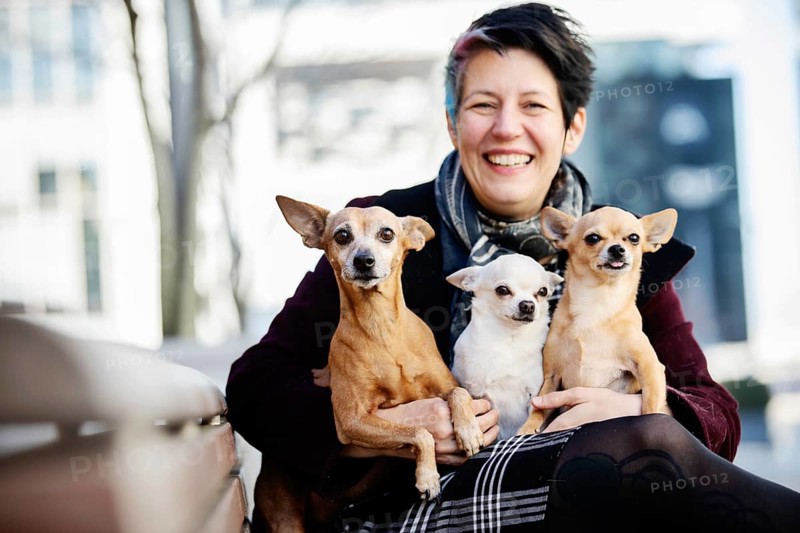 Laughing woman with three dogs on her lap