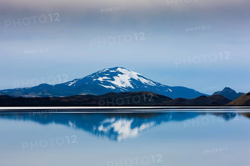 Reflection of the snow-covered volcanic cone Hekla in Hrauneyjalon