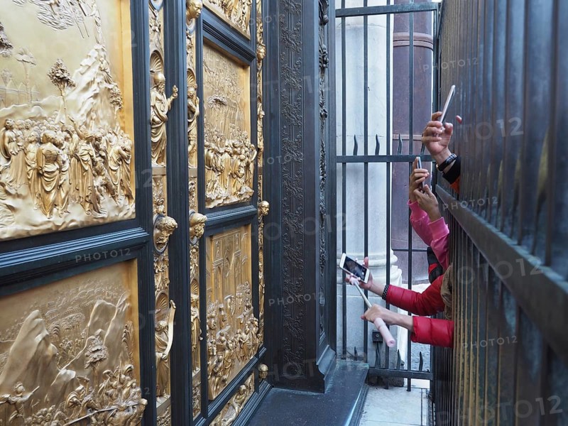 Tourists photograph with smartphone the paradise door in Florence