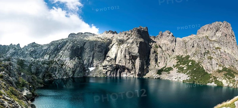 Mountain lake Lac de Capitello surrounded by steep faces