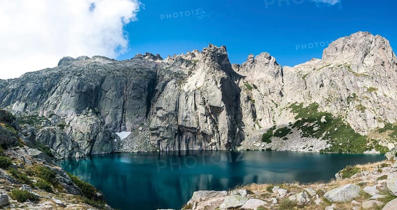 Mountain lake Lac de Capitello surrounded by steep faces