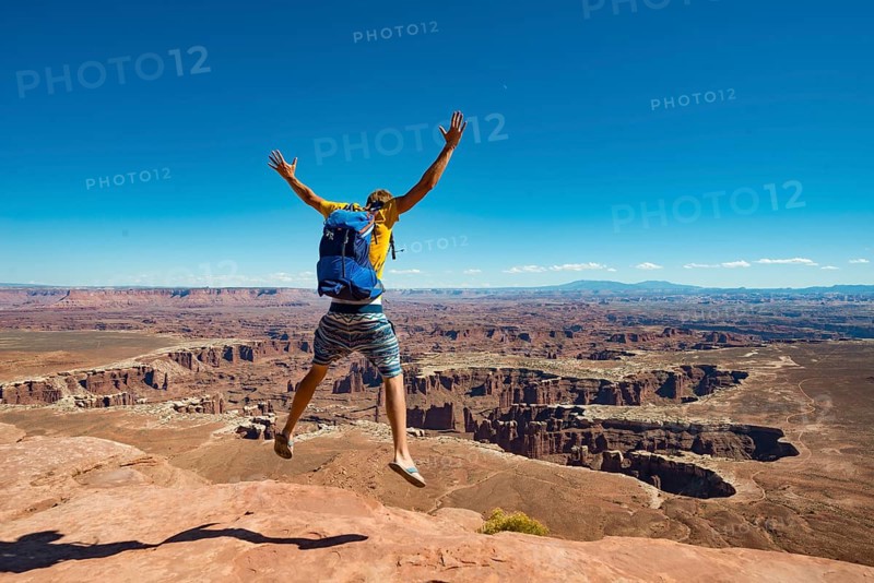 Young man jumping with outstretched arms