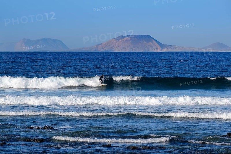 Wave surfers on waves at Caleta de Famara