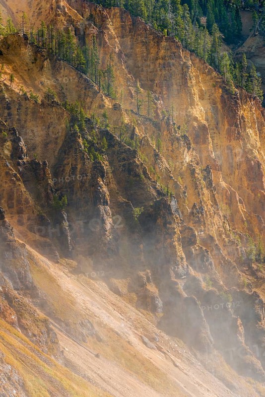 Rugged rock face of the Grand Canyon of the Yellowstone with water vapor of the waterfall