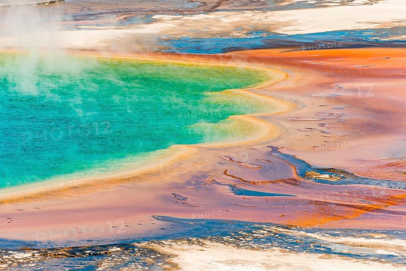 Colored mineral deposits at the edge sr steaming hot spring