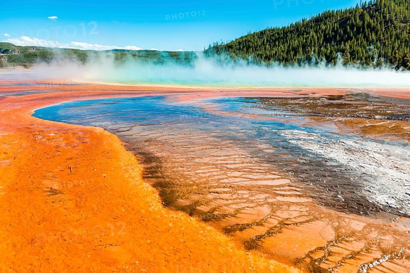 Colored mineral deposits at the edge of the steaming hot spring