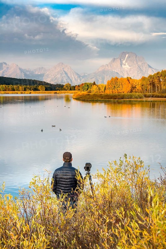 Photographer standing with tripod at the river