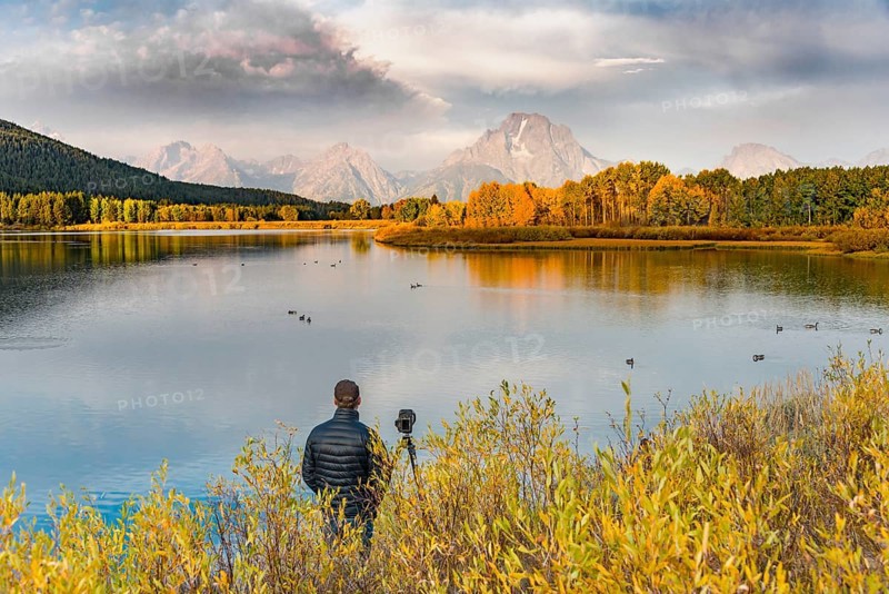 Photographer standing with tripod at the river