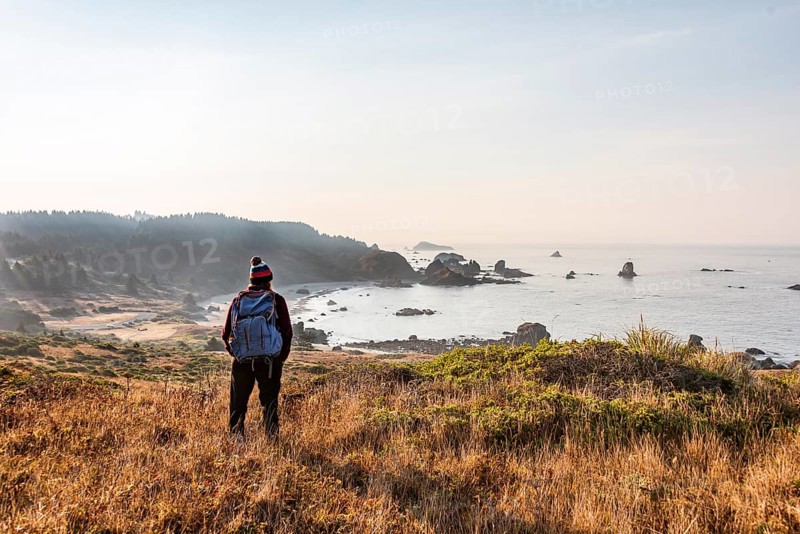 Female hiker looking out for coastal scenery with many rugged rocky islands