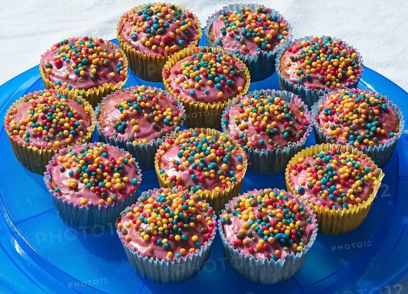 Cupcakes with colorful sugar pearls on blue plate