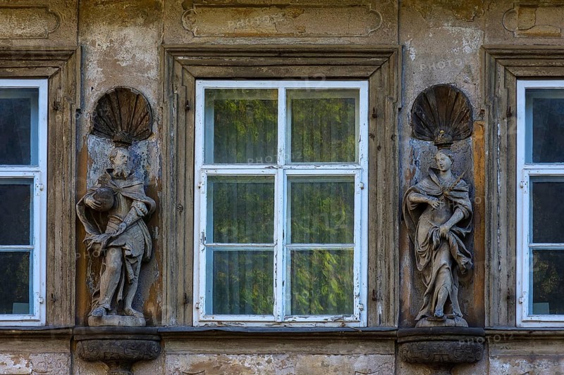 Wooden sculptures of Emperor Heinrich II and Empress Kunigunde on a facade of a house between windows