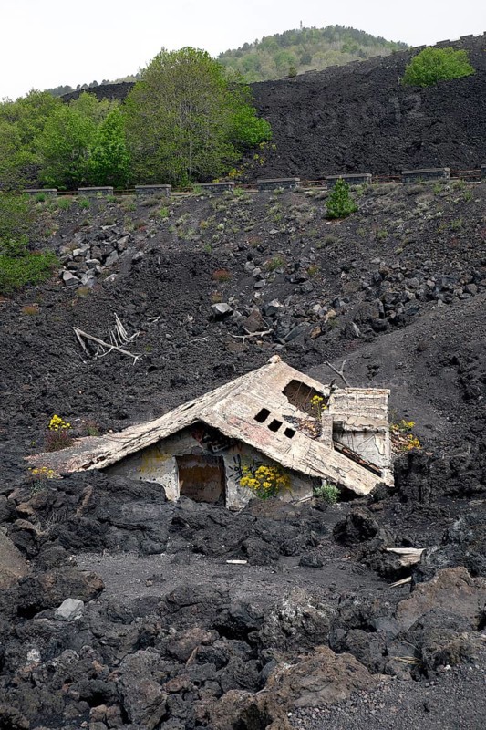 House covered with lava on the slopes of Mount Etna