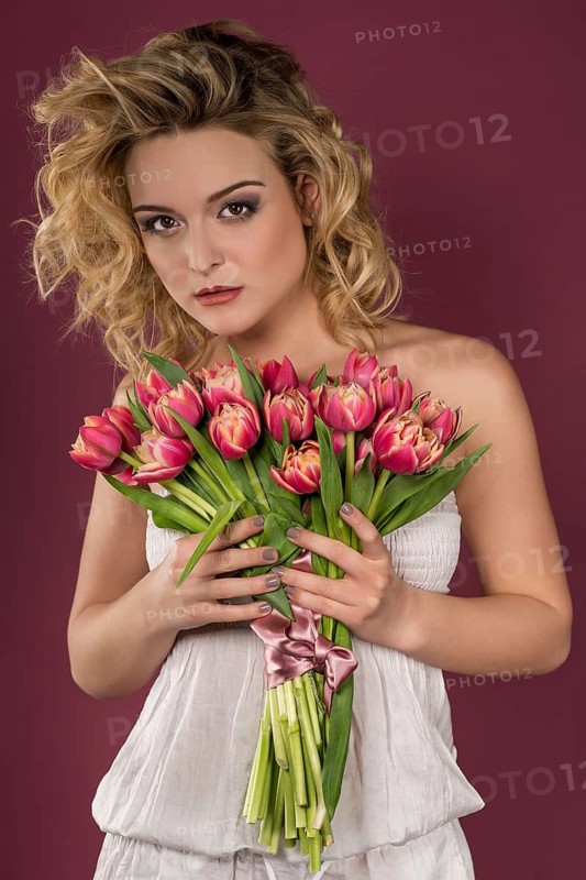 Young woman posing with bouquet of flowers