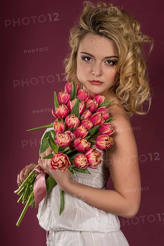 Young woman posing with bouquet of flowers