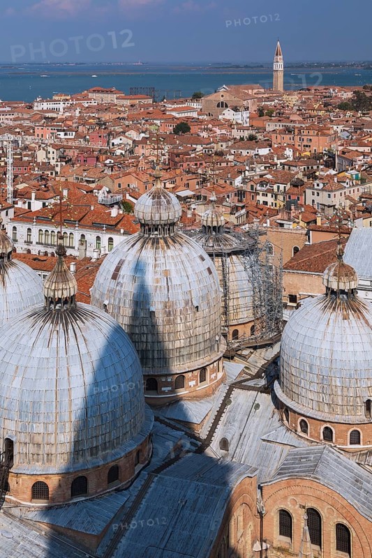 St Mark's Basilica with Romanesque domes and ornate Gothic and Byzantine architectural details plus old Renaissance architectural style residential buildings with terracotta rooftops and lagoon