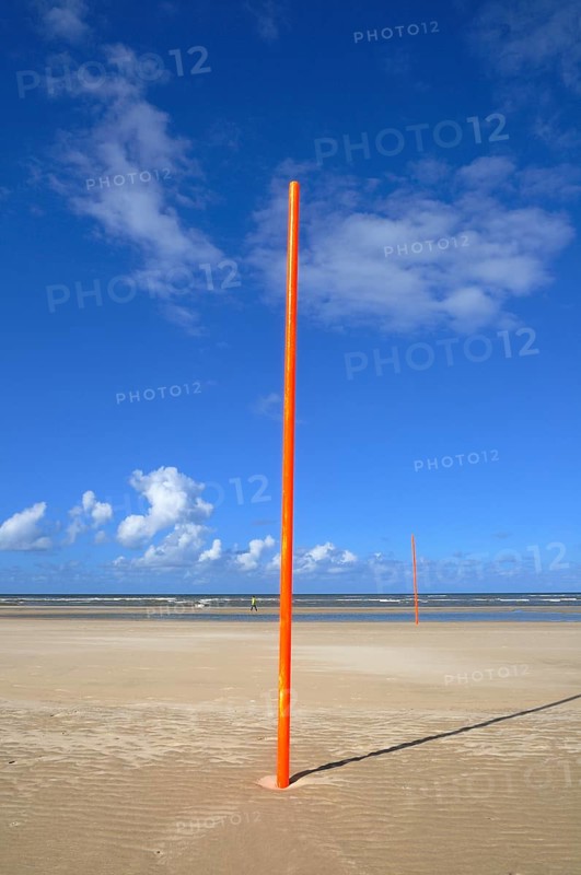 Orange-red marker posts on the beach