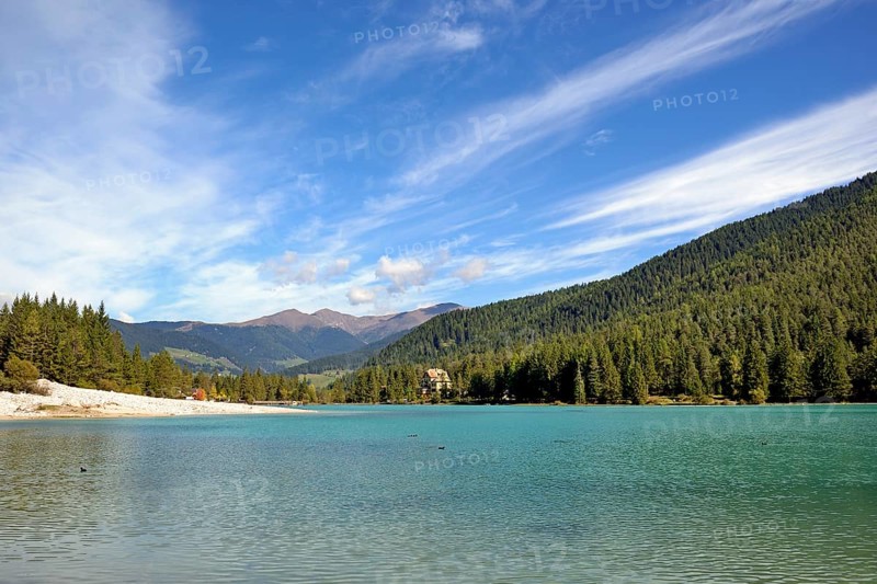 View over the emerald green lake Dobbiaco with mountain forest and Murengang