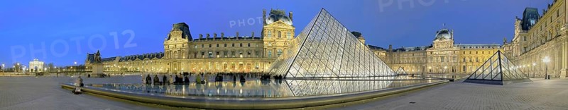 Illuminated Louvre with glass pyramid at dusk