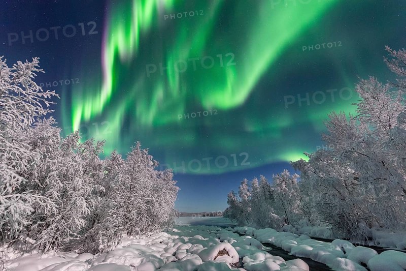Northern Lights (Aurora Borealis) over snowy river landscape