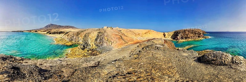 Rocky coastline and sandy beach with turquoise waters of Playa del Papagayo