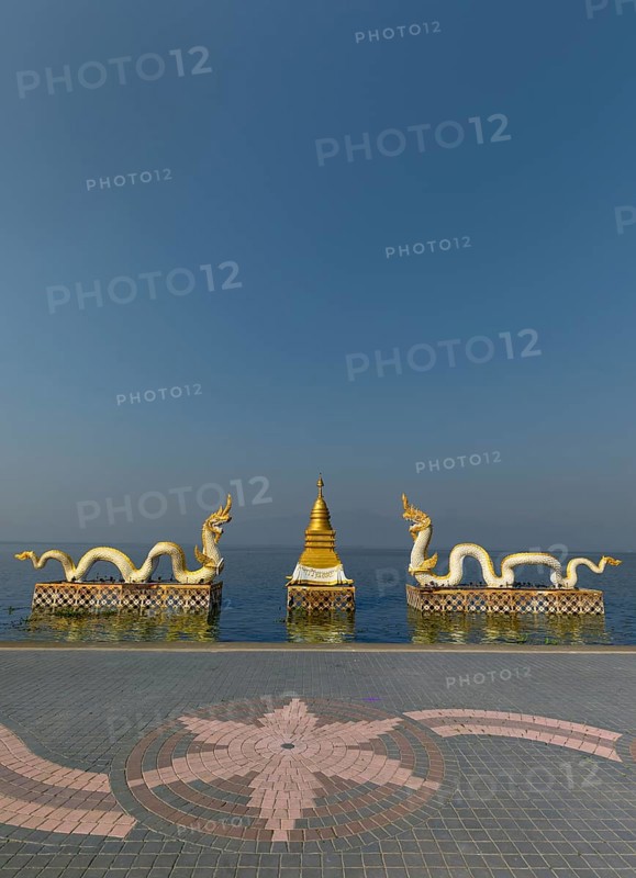 White Naga statues with golden Chedi on the shore of Lake Kwan Phayao
