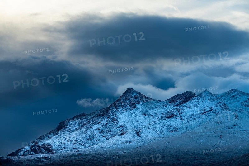 Snow-covered mountain peaks of the Cullins Group with clouds in snow-covered landscape