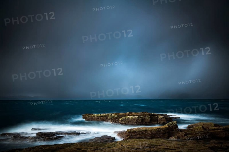 Large rocks in the waters of the North Sea with thunderclouds
