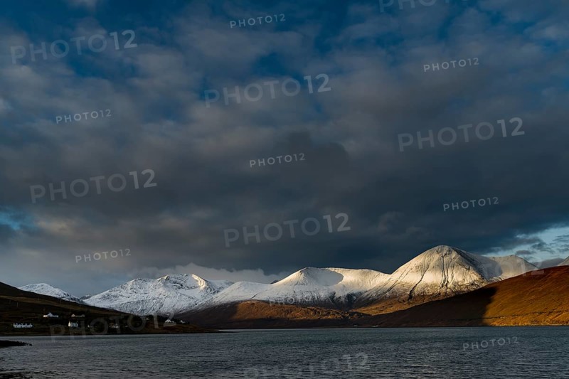 Snow-covered Cullins mountain range with Loch Ainort in dramatic light