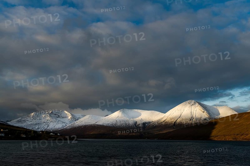 Snow-covered Cullins mountain range with Loch Ainort in dramatic light