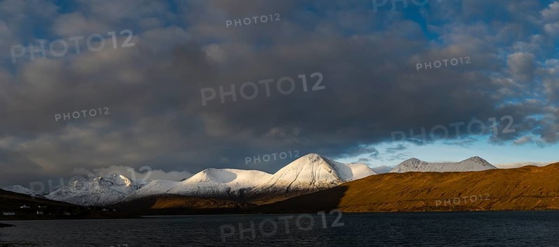 Snow-covered Cullins mountain range with Loch Ainort in dramatic light