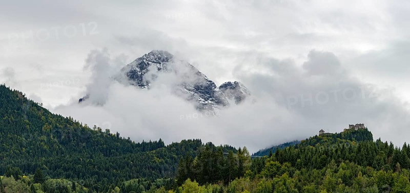 Castle ruin Ehrenberg with deciduous forest and mountains in the fog