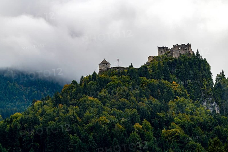 Castle ruin Ehrenberg with deciduous forest and mountains in the fog