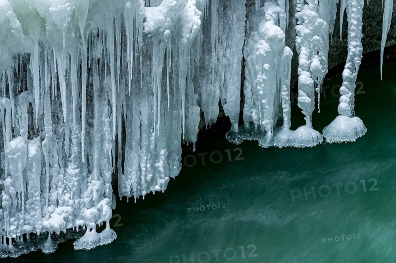 Icicles over running water