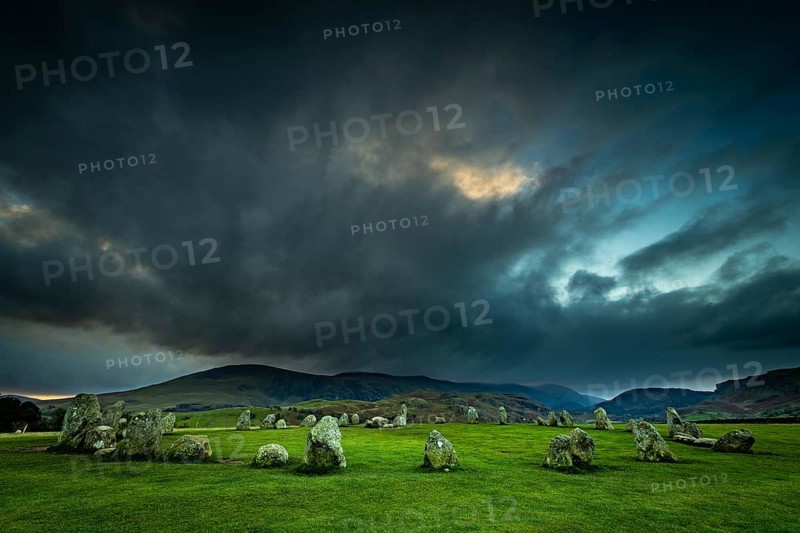 Stone circle with dramatic dark cloud sky